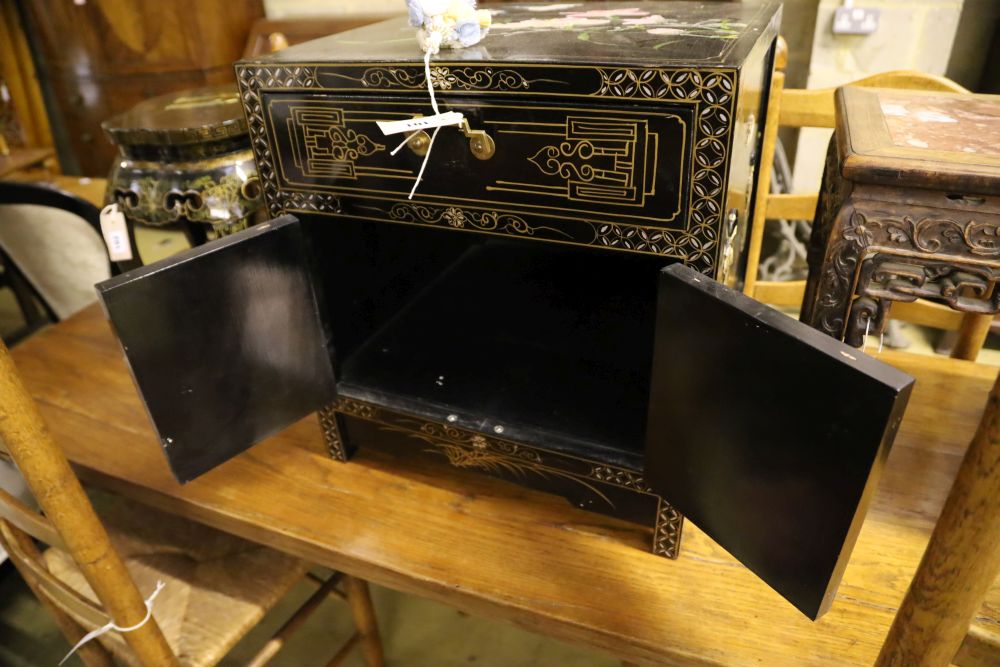 A Chinese black-lacquered brass-mounted small two-door cabinet, the door panels decorated with figures, width 51cm, depth 51cm, height